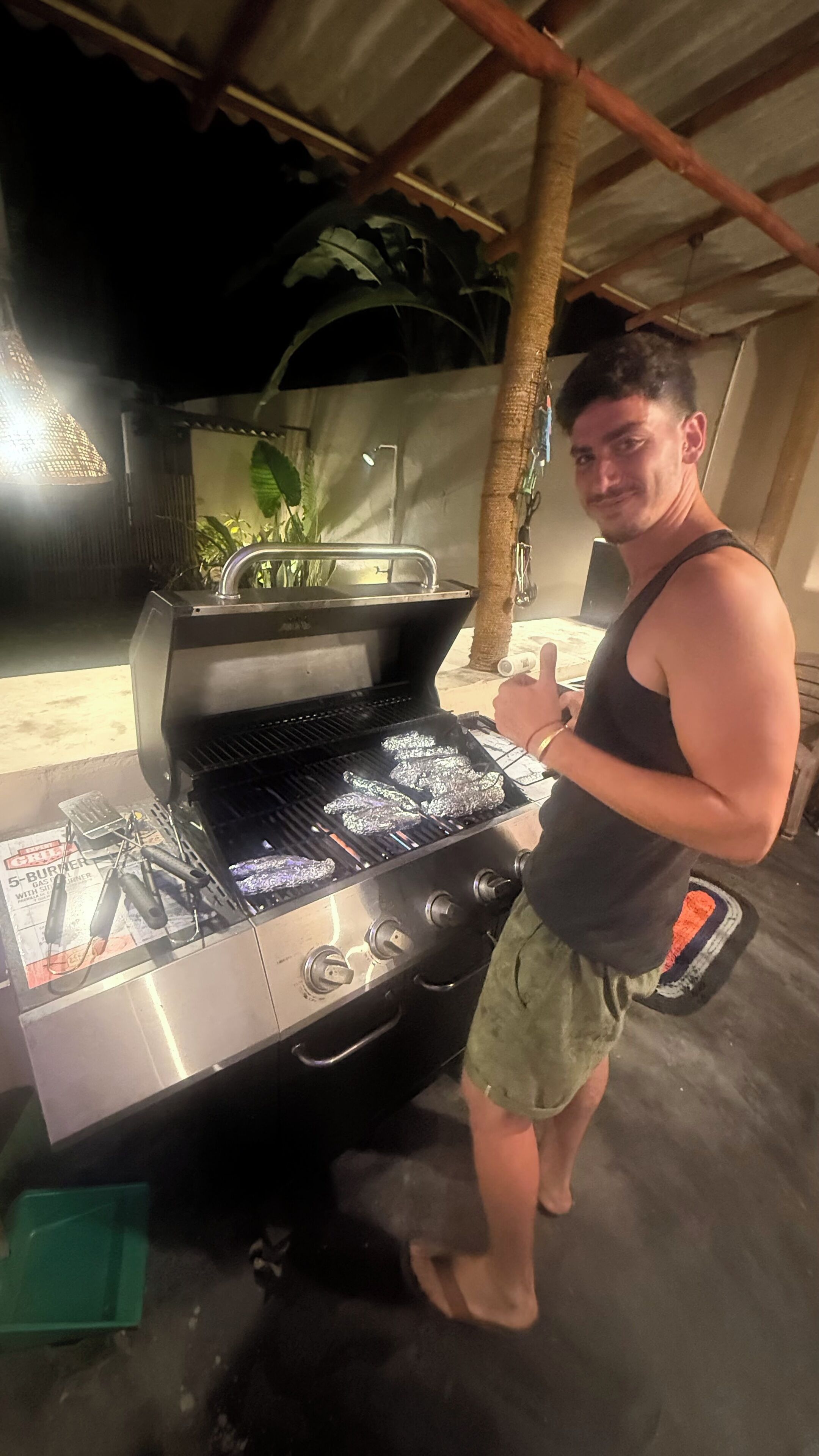 A person grilling outdoors at night.