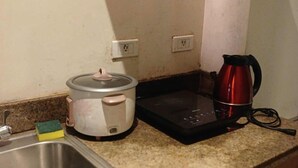 Une cuisine équipée d’un évier, d’une mijoteuse, d’une machine à café et d’un plan de travail.