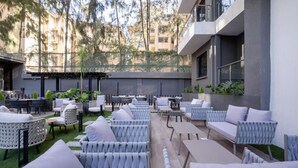 Een terras met rieten meubels en een kleine bar.