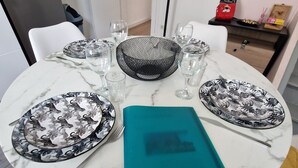 Een eettafel gedekt met borden, glazen en een menukaart.