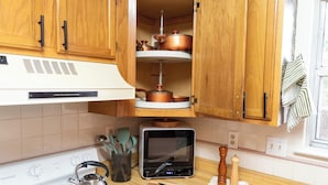 Eine Küche mit Holzausstattung, einem Backofen, einer Mikrowelle und einem Herd.