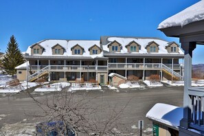 A multi-story hotel with a central courtyard, covered balconies, and a snow-covered exterior.