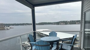 A balcony with a table and chairs overlooking a body of water.