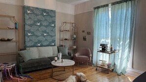 Ein gemütliches Wohnzimmer mit einer Couch, einem Couchtisch, einem Hund, der auf dem Boden liegt, und einem Bücherregal.