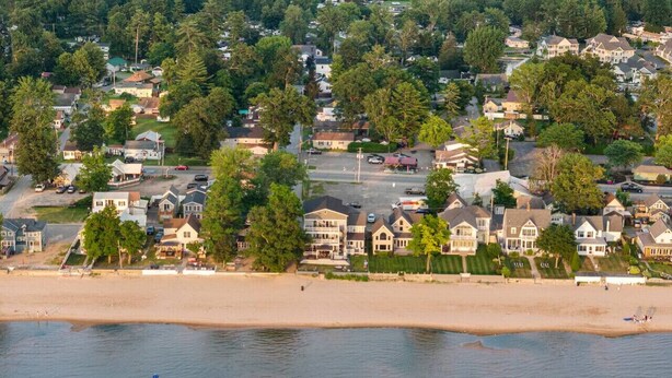 Une zone résidentielle côtière avec des maisons, une plage et une eau calme.