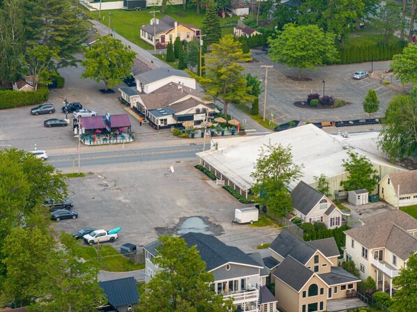 A residential area with houses, a parking lot, and a small commercial building with outdoor seating.