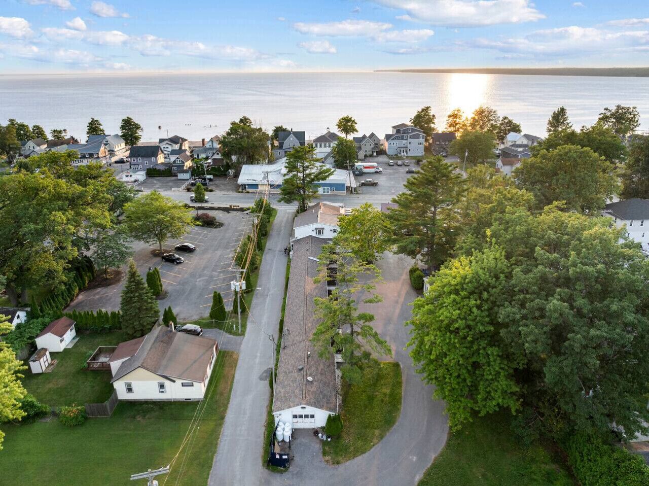 Vista aérea de una zona residencial con casas, un estacionamiento y una carretera que lleva al mar.