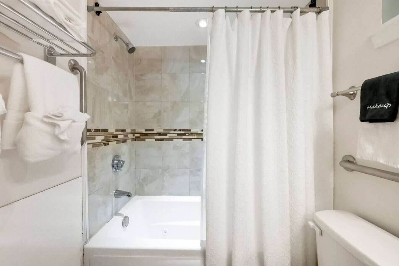 Un baño moderno con cabina de ducha de vidrio, bañera y retrete.