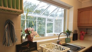 A kitchen with a window, a sink, and a dish rack.