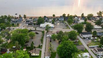 A residential area with houses, a parking lot, and a body of water in the background.
