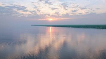A calm body of water reflecting the sky during sunset.