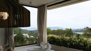 A hotel room with a large bed, a view of a mountainous landscape, and a balcony with flowers. - Villa Jaisai 4-bedroom Sea View & On-Site chef (Chaweng)