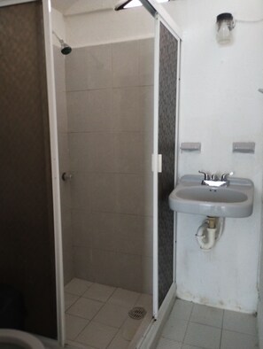 Une salle de bain avec une douche, un lavabo et des toilettes.