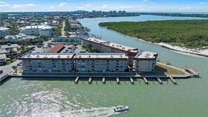 Un hôtel situé au bord de l’eau, composé de plusieurs bâtiments, avec un quai où sont amarrés des bateaux et une marina.