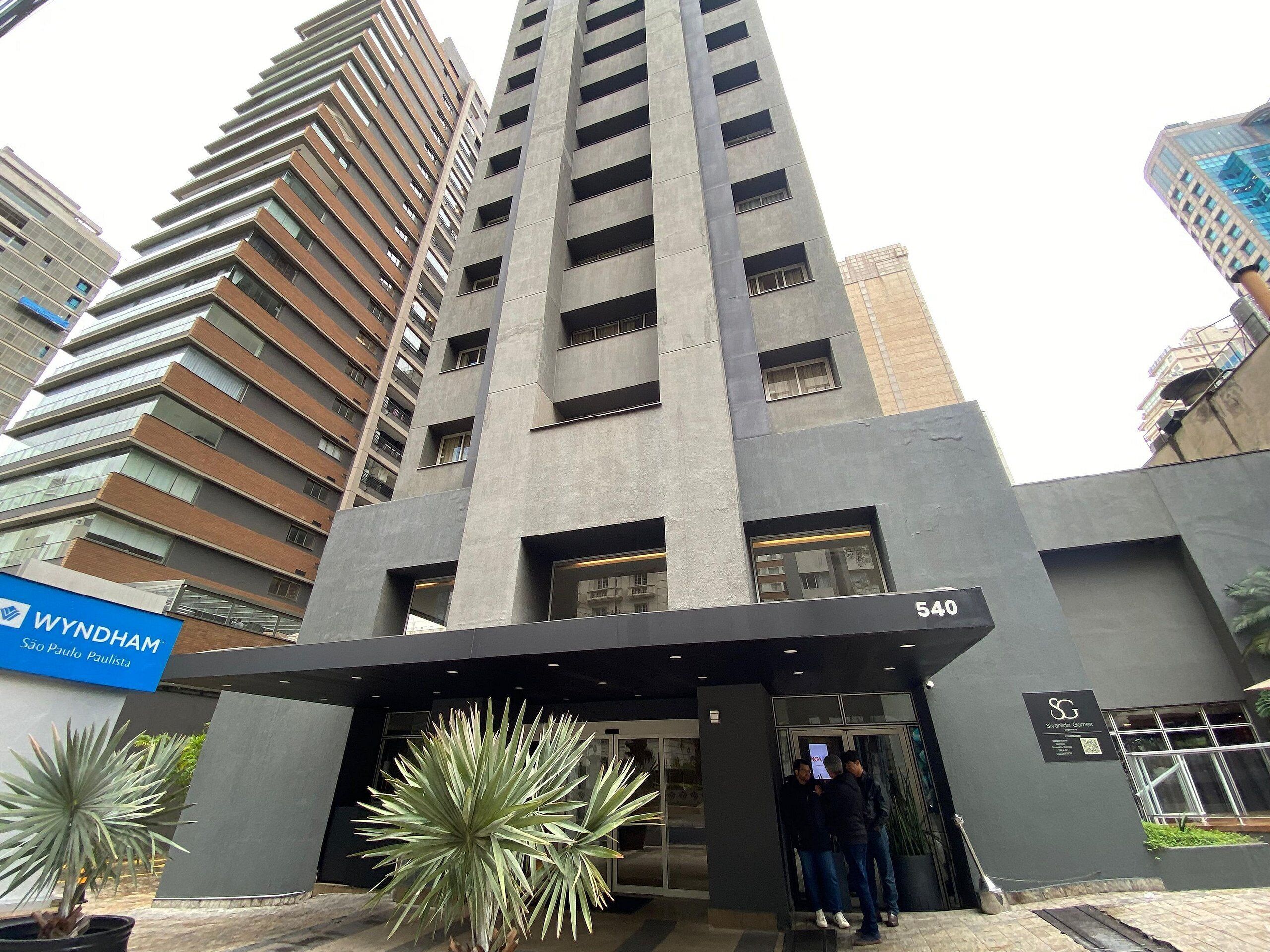 Ein modernes Gebäude mit einem markanten Eingang, einem Schild mit der Aufschrift 'Wyndham São Paulo Paulista' und der Nummer 540 an der Fassade.
