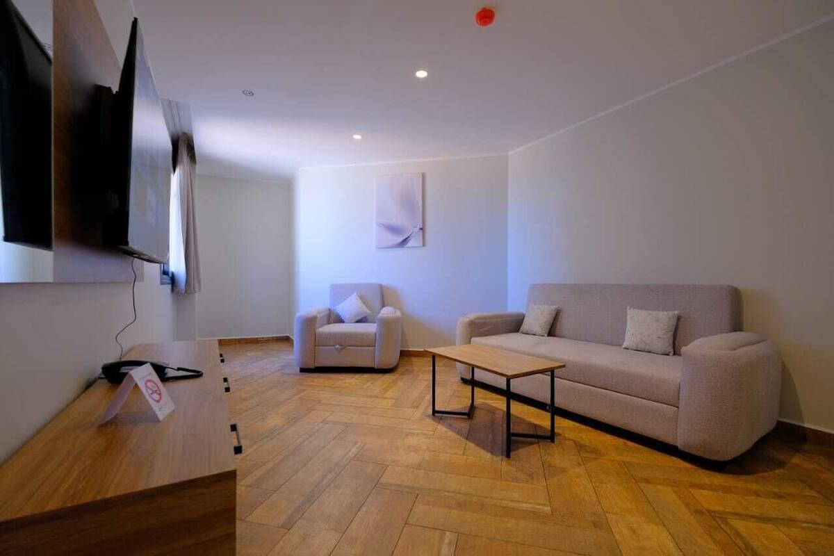 A modern living room with a sofa, armchair, and a coffee table.