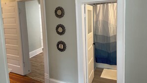 Un pasillo con una puerta que da a un baño con cortina de ducha.