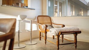 A room with a wooden chair, a floor lamp, and a window with blinds. - Desert Retreat-Spacious home W/Large In-ground Pool, Hot Tub, Mountain Sunsets (Yucca Valley)