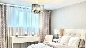 A bedroom with a large bed, a desk, a chair, and a hanging light fixture. - EXCEPTIONAL, CONTEMPORARY 2BD/1BA  4 miles from MAYO (Rochester)
