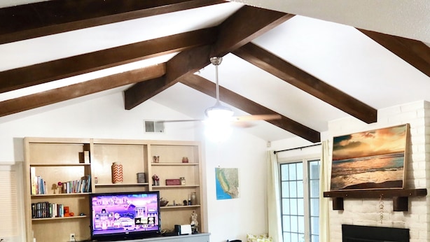 Una sala de estar con chimenea, televisor y estantería.