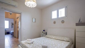 A bedroom with a bed, bedside tables, a dresser, and a window. - [Shell House] AC|Wi-Fi|P private|BBQ (Castelvetrano)