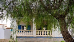 A building with a balcony, a tree in front, and a white wall. - [Shell House] AC|Wi-Fi|P private|BBQ (Castelvetrano)