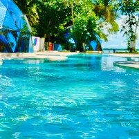 Piscina cristalina con vistas a una zona de resort tropical.