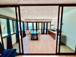 Un interior moderno con comedor, cocina y ventanas amplias que ofrecen vistas.