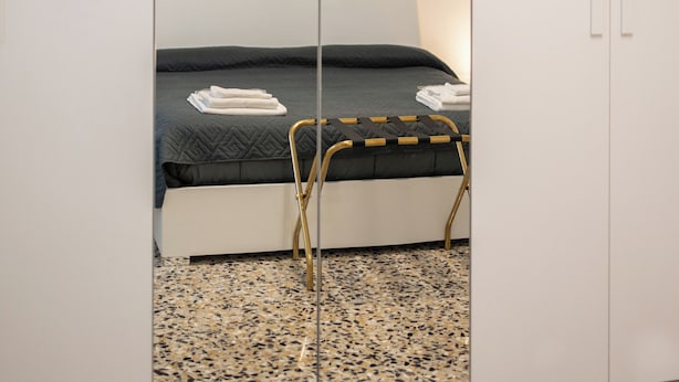 A bedroom with a bed, a mirror, and artwork on the wall. - Al Pettirosso: 15 min to Venice, 2 Double Bedrooms, Free Private Parking (Venezia)