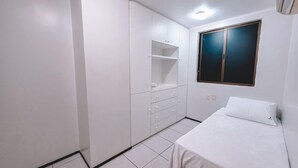 A small, white room with a bed, a wardrobe, and a window. - Flat Atlantic Ocean - Praia de Iracema (Fortaleza)
