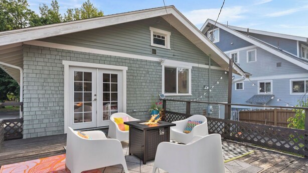 A covered patio with a fire pit, white chairs, and a patterned rug. - Manito Craftsman with Fire Pit (Spokane)