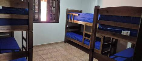 Un dormitorio con literas, una ventana con vistas y suelo de baldosas.