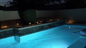 A swimming pool with a stone border and a tree in the background. - Sunset Stadium Stay! 5 Min Drive to State Farm Stadium, Westgate, Top Golf (Glendale)