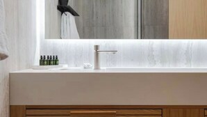 Un baño moderno con un espejo grande, un lavabo y una ducha.