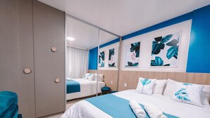 A hotel room with a large bed, a wardrobe, a mirror, and artwork on the wall. - Compacto de luxo - One Milênio Cocô (Fortaleza)
