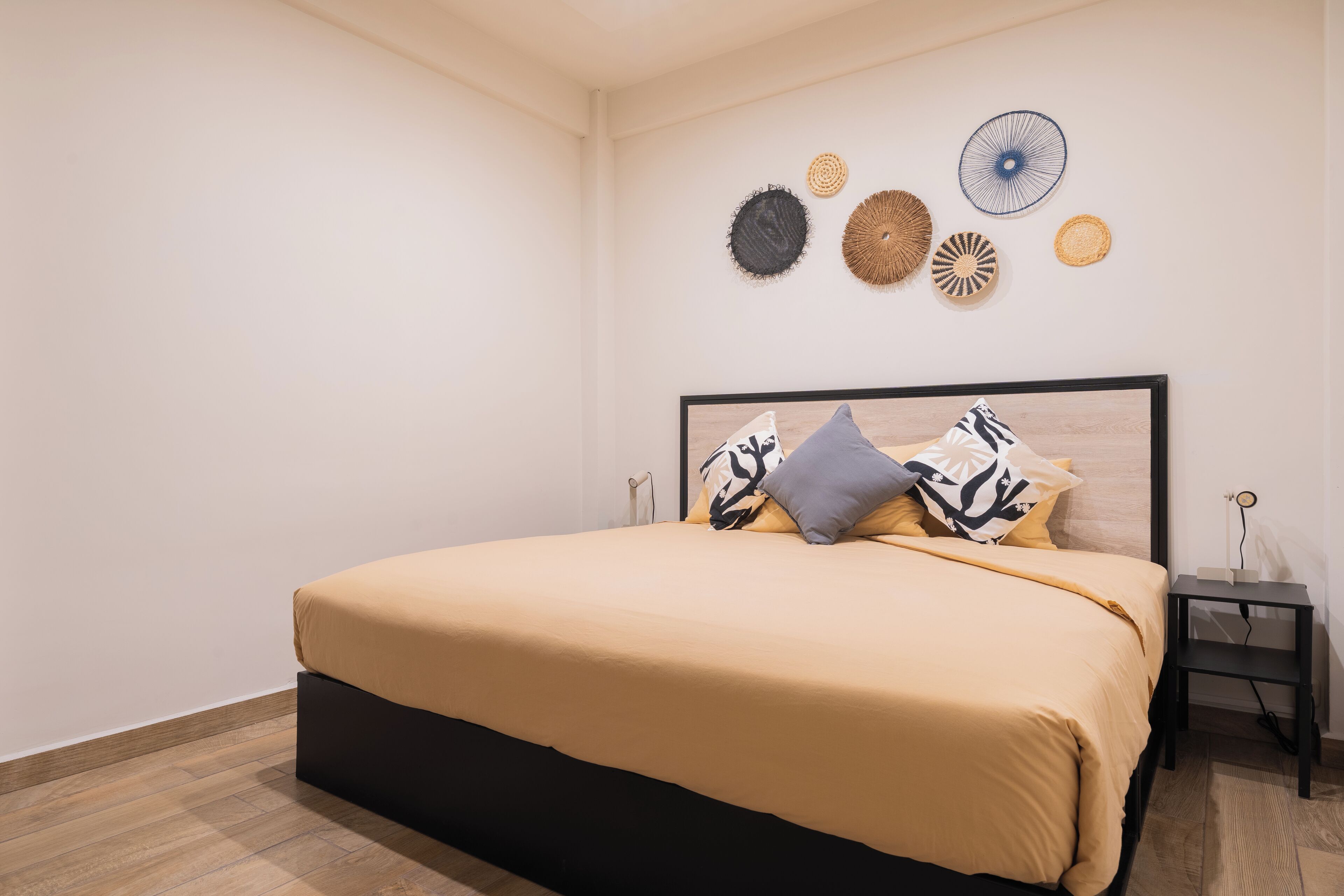 A bedroom with a bed, a nightstand, and wall decor.
