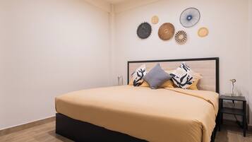 A bedroom with a bed, a nightstand, and wall decor.