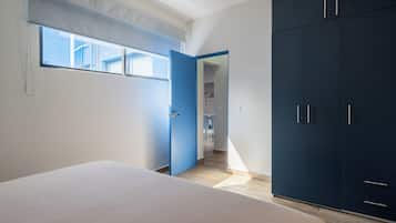 A bedroom with a bed, a wardrobe, and a window.