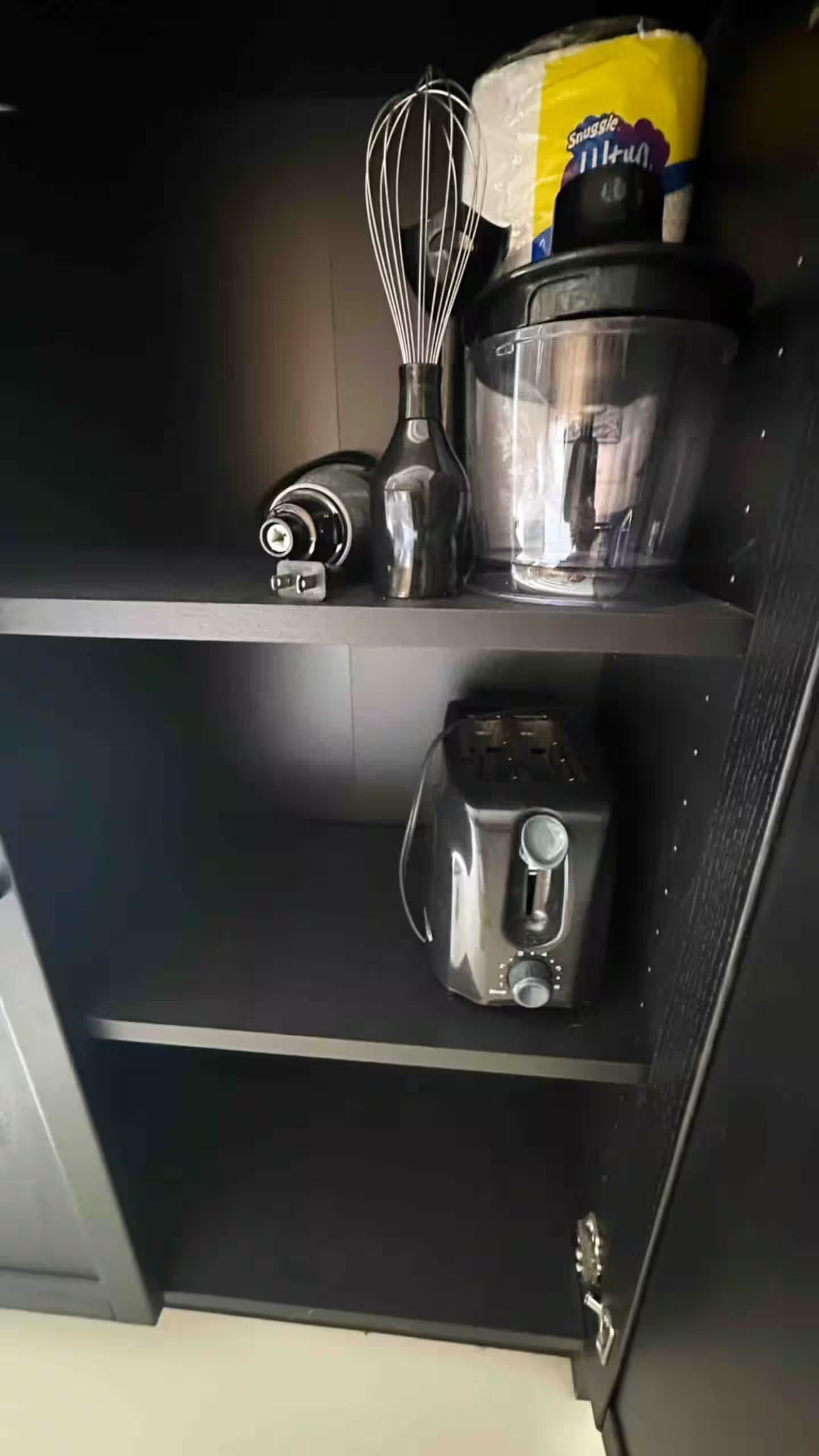 Een keuken met een blender, een garde en een broodrooster op het aanrecht.
