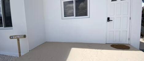 A white building with a door marked "242" and a window.