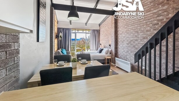Un intérieur moderne comprenant un coin repas, un canapé et un escalier.