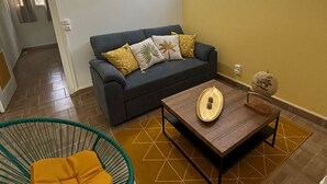 Een woonkamer met een bank, een bijzettafeltje en een fauteuil.
