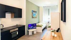 Um espaço compacto com cozinha compacta, área de refeições e quarto.
