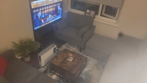 A living room with a television, a radiator, a sofa, and a coffee table. - Sefton Park n Princes Park and Lark Lane the other end of Linnet and bus to LFC (Liverpool)