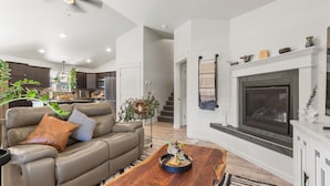A modern living room with a leather sofa, a wooden coffee table, and a fireplace.