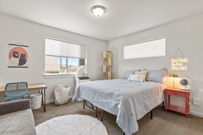 Une chambre à coucher avec un lit, un bureau, une chaise, un radiateur et une fenêtre.