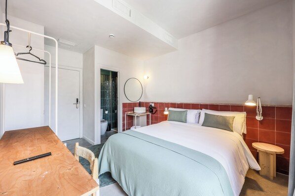 A hotel room with a bed, a desk, a chair, a round mirror, and a small table. - Password to Madrid Casa de Campo (Self Check in) (Madrid)