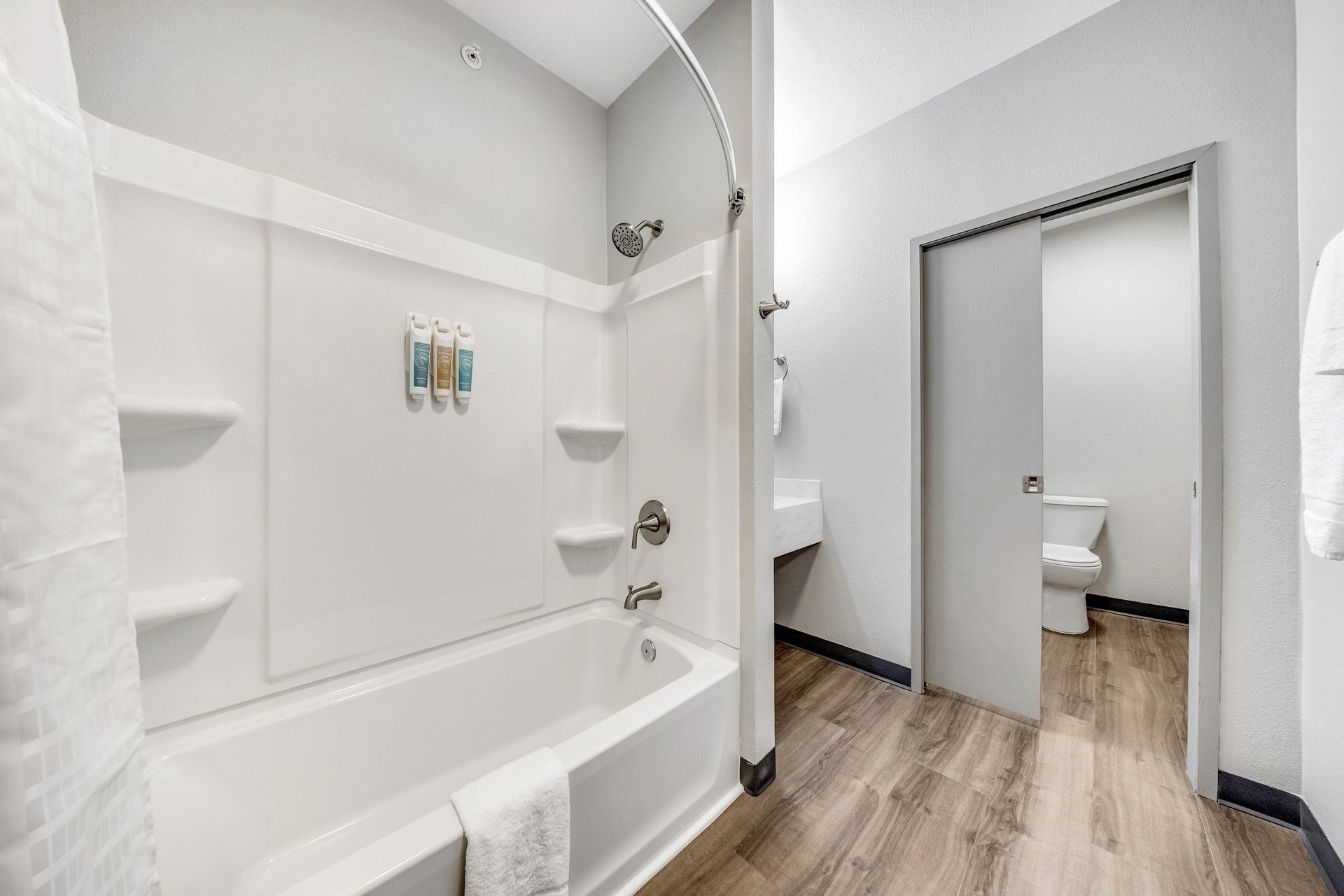 A modern bathroom with a bathtub, shower, and toilet.