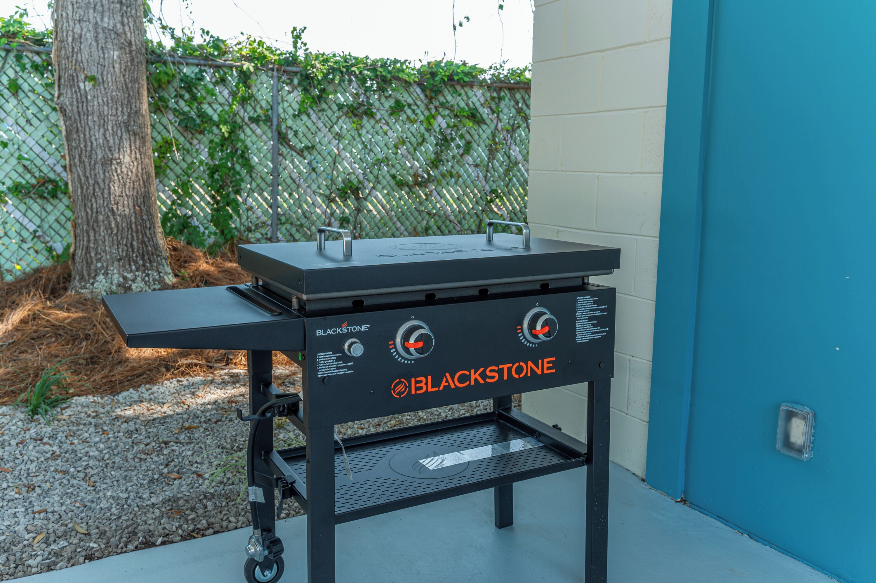 Een Blackstone grill met twee branders, een bijzettafel en een metalen frame.