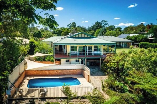 A two-story house with a swimming pool in the backyard.